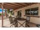 Shaded patio with an outdoor dining set and partial view of the backyard at 9265 E Kalil Dr, Scottsdale, AZ 85260