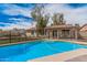 Backyard pool featuring a safety fence, views of the house, a manicured lawn, and desert landscaping at 9265 E Kalil Dr, Scottsdale, AZ 85260