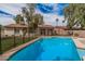 Backyard pool with safety fence, green turf, and a view of the house on a sunny day at 9265 E Kalil Dr, Scottsdale, AZ 85260