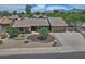 An elevated view of a charming single-story home with a large front yard and mountain views at 9476 E Laurel Ln, Scottsdale, AZ 85260