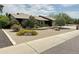 Charming single-story home featuring desert landscaping with mature trees and stone accents at 9476 E Laurel Ln, Scottsdale, AZ 85260