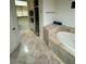 Bathroom showcasing a soaking tub, tiled floors, and a walk-in shower, providing a spa-like retreat at 10175 E Cochise Dr, Scottsdale, AZ 85258