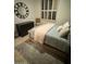 Comfortable bedroom featuring plush bed, decorative wall clock, and natural light from window at 10175 E Cochise Dr, Scottsdale, AZ 85258