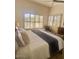 Comfortable bedroom featuring a plush bed, ceiling fan, and an abundance of natural light from the window at 10175 E Cochise Dr, Scottsdale, AZ 85258