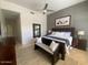 Bedroom with a ceiling fan, a large bed with decorative pillows, and a cozy bench creating a relaxing space at 10175 E Cochise Dr, Scottsdale, AZ 85258