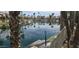 Scenic waterfront view from the property, reflecting the blue sky, surrounded by palm trees and lush landscaping at 10175 E Cochise Dr, Scottsdale, AZ 85258