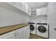 Well-lit laundry room featuring front-loading washer/dryer, wooden countertop and plenty of cabinet storage at 1441 W Sea Haze Dr, Gilbert, AZ 85233
