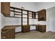 A home office featuring ample built-in desk space, drawers, shelving, and wood flooring at 1441 W Sea Haze Dr, Gilbert, AZ 85233