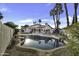 Backyard pool area with rock detail, grass and a covered patio area at 1441 W Sea Haze Dr, Gilbert, AZ 85233