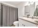 Well-lit bathroom features updated sink and vanity, toilet, and shower with gray curtain at 14801 N 25Th Dr # 2, Phoenix, AZ 85023