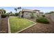 Landscaped backyard with grassy area, patio, and mature trees under a blue sky at 15064 N 54Th Way, Scottsdale, AZ 85254