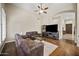 Cozy living room featuring a comfortable leather sofa, neutral walls, ceiling fan, and modern entertainment center at 15064 N 54Th Way, Scottsdale, AZ 85254