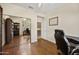 A bonus room with a dark desk, wood floors, a ceiling fan, and mirrored closet doors at 15064 N 54Th Way, Scottsdale, AZ 85254