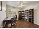 Comfortable office with wood floors, a ceiling fan, a desk, and built-in bookcases at 15064 N 54Th Way, Scottsdale, AZ 85254