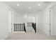 Bright upstairs hallway with neutral carpet, black railing, and recessed lighting at 17854 W Mission Ln, Waddell, AZ 85355
