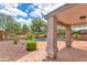 Relaxing backyard with covered patio, pool, and mature desert landscaping under a sunny sky at 1821 E Patrick Ln, Phoenix, AZ 85024