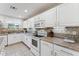 Bright kitchen featuring white cabinets, modern appliances, and tiled backsplash and flooring at 1821 E Patrick Ln, Phoenix, AZ 85024