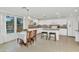 Bright kitchen features an island with bar seating, tile floors, white cabinetry, and a cozy dining area with backyard views at 1821 E Patrick Ln, Phoenix, AZ 85024