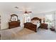 Spacious main bedroom with wood furnishings, a ceiling fan, neutral carpet and decor, and great natural light at 1821 E Patrick Ln, Phoenix, AZ 85024