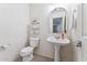 Clean powder room with a pedestal sink, decorative mirror, and tiled flooring for a stylish and functional space at 1821 E Patrick Ln, Phoenix, AZ 85024