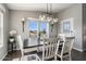 Cozy dining room with a modern chandelier and backyard views, creating a warm and inviting space at 2206 S Ellsworth Rd # 160B, Mesa, AZ 85209