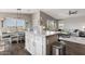 Open-concept kitchen flows into the living room, featuring an island with bar stools and sleek appliances at 2206 S Ellsworth Rd # 160B, Mesa, AZ 85209