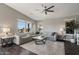 Spacious living room with a comfortable gray sectional, ceiling fan, and natural light, great for relaxing at 2206 S Ellsworth Rd # 160B, Mesa, AZ 85209