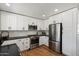 Modern kitchen featuring white cabinets, stainless steel appliances, and dark countertops at 2223 E Roma Ave, Phoenix, AZ 85016
