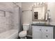 This modern bathroom features marble tile, stylish fixtures, and a decorative vanity mirror at 225 W 1St St # 107, Mesa, AZ 85201