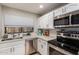 Well-lit kitchen featuring stainless steel appliances and white cabinets at 225 W 1St St # 107, Mesa, AZ 85201