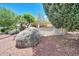 Beautiful landscaping surrounds this backyard featuring desert foliage and red rock at 23309 N Las Positas Ct, Sun City West, AZ 85375