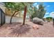 Well-landscaped backyard featuring desert landscaping, a covered patio, and a peaceful outdoor environment at 23309 N Las Positas Ct, Sun City West, AZ 85375