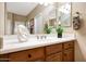 Close up of sink with cherry cabinets, decor, and tile floors in the bathroom at 23309 N Las Positas Ct, Sun City West, AZ 85375