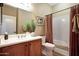 Bathroom view with cherry cabinets, a sink, toilet, and shower-tub combo at 23309 N Las Positas Ct, Sun City West, AZ 85375