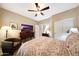 Bedroom with bed, ceiling fan, TV, and sitting chair at 23309 N Las Positas Ct, Sun City West, AZ 85375