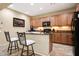 Well-equipped kitchen featuring granite countertops, black appliances, and modern bar stools at 23309 N Las Positas Ct, Sun City West, AZ 85375