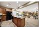 Open-concept kitchen featuring an island with granite countertops and seamless flow into the living room at 23309 N Las Positas Ct, Sun City West, AZ 85375