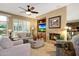 Cozy living room with a fireplace, built-in shelving, comfortable seating, and bright natural light at 23309 N Las Positas Ct, Sun City West, AZ 85375