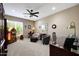 Well-lit office featuring a vintage jukebox, accent furniture, and neutral-toned walls and carpet at 23309 N Las Positas Ct, Sun City West, AZ 85375