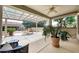Inviting covered patio with a ceiling fan, comfortable seating, and views of the beautifully landscaped backyard at 23309 N Las Positas Ct, Sun City West, AZ 85375