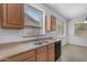 Functional kitchen space with dual stainless sink, dark dishwasher, and natural light for convenience at 29475 N Candlewood Dr, San Tan Valley, AZ 85143