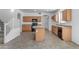 Open-concept kitchen with light wood cabinets, an island, and black appliances, ideal for cooking at 29475 N Candlewood Dr, San Tan Valley, AZ 85143