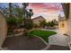 Backyard featuring a putting green, mature palm trees, and manicured landscaping at 3102 E Desert Broom Way, Phoenix, AZ 85048