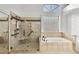 Bright main bathroom features glass enclosed shower, soaking tub, and stylish tile work at 3102 E Desert Broom Way, Phoenix, AZ 85048