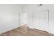 Bright bedroom featuring wood-look floors, white walls, a ceiling fan, closet, and access to another room at 3102 E Desert Broom Way, Phoenix, AZ 85048