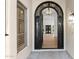 Foyer with an arched entryway, decorative iron door, and hardwood floors at 3102 E Desert Broom Way, Phoenix, AZ 85048