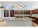 Granite island counters paired with stainless appliances and pendant lighting at 3102 E Desert Broom Way, Phoenix, AZ 85048