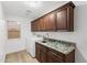 The spacious laundry room has upper and lower cabinets with granite counters and a large window to let in natural light at 3102 E Desert Broom Way, Phoenix, AZ 85048