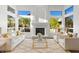 Bright living room with white furniture, fireplace, and large windows with greenery view at 3102 E Desert Broom Way, Phoenix, AZ 85048
