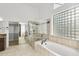 Bright main bathroom features a glass enclosed shower, soaking tub, and walk-in closet at 3102 E Desert Broom Way, Phoenix, AZ 85048
